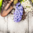 Rusty garden trowel with soil and freshly dug hyacinth bulbs and flowers on a rustic wooden surface.