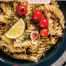 Fusilli with tomatoes and fresh basil served in a blue bowl with lemon and garlic — easy homemade tomato pasta recipe for two.