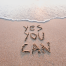 Inspiration for 2026 message written in sand reading “Yes You Can” by the sea