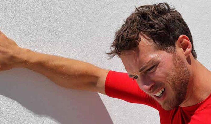 A man looking dehydrated, sweating profusely, with a fatigued expression