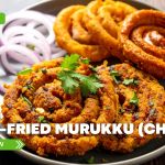 Plate of crispy air-fried murukku, also known as chakli, garnished with coriander and served with sliced onions, featured by Prime Magazine as a healthy Indian snack recipe.