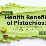 Fresh pistachios scattered on a green pistachio cream background, representing the health and energy benefits of pistachios for weight management and heart health.