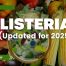 Article banner titled ‘Listeria (Updated for 2025)’ over a background of fresh vegetables with a magnified illustration of Listeria bacteria.
