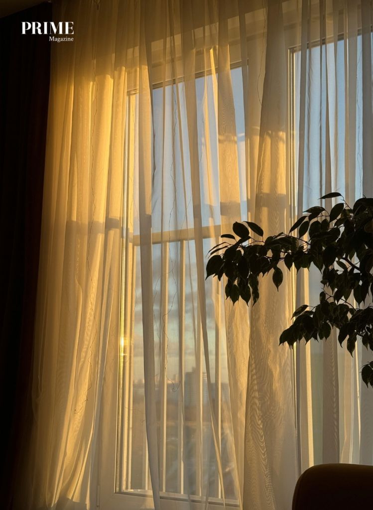 Sunlight streaming through an open window with soft curtains, symbolising stillness, presence, and a gentler relationship with time later in life.
