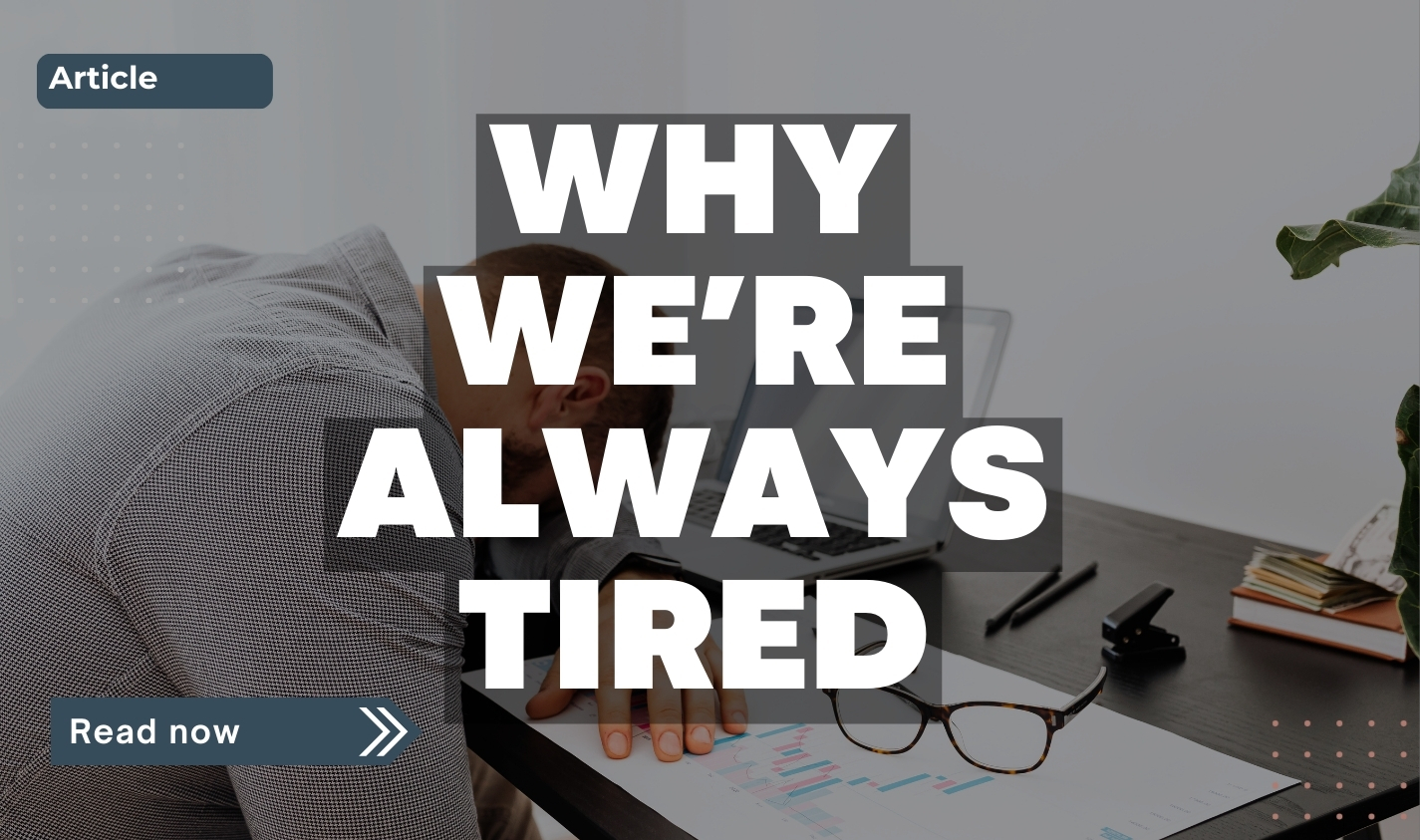 A tired man slumped over a desk with his head resting on his arm beside a laptop, paperwork, and glasses, representing chronic fatigue and burnout.