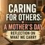 A warm-toned Mother’s Day image showing a mother sitting quietly beside a table with flowers, a greeting card and a mug, alongside the words “Caring for Others: A Mother’s Day Reflection on What We Carry.”