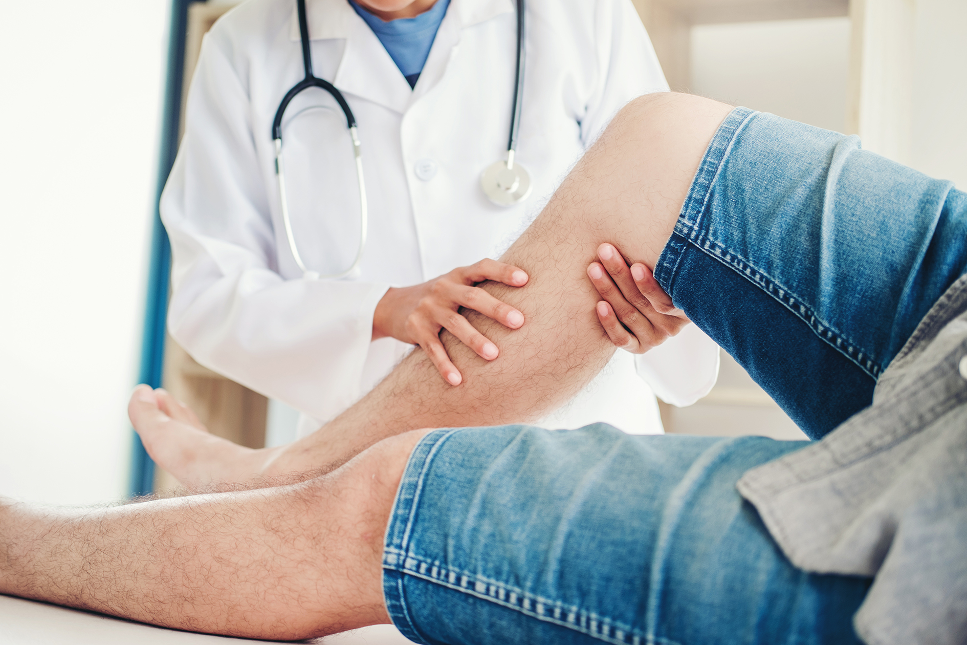 doctor examining patient's leg during physical therapy treatment for nerve pain